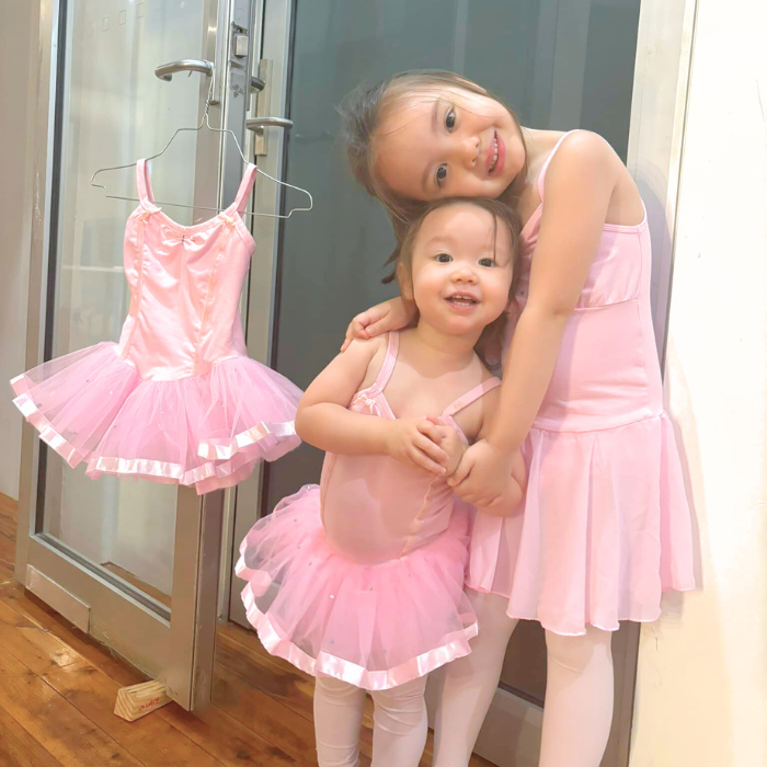 Two sisters in ballet tutus hugging during ballet dance classes in Sydney.
