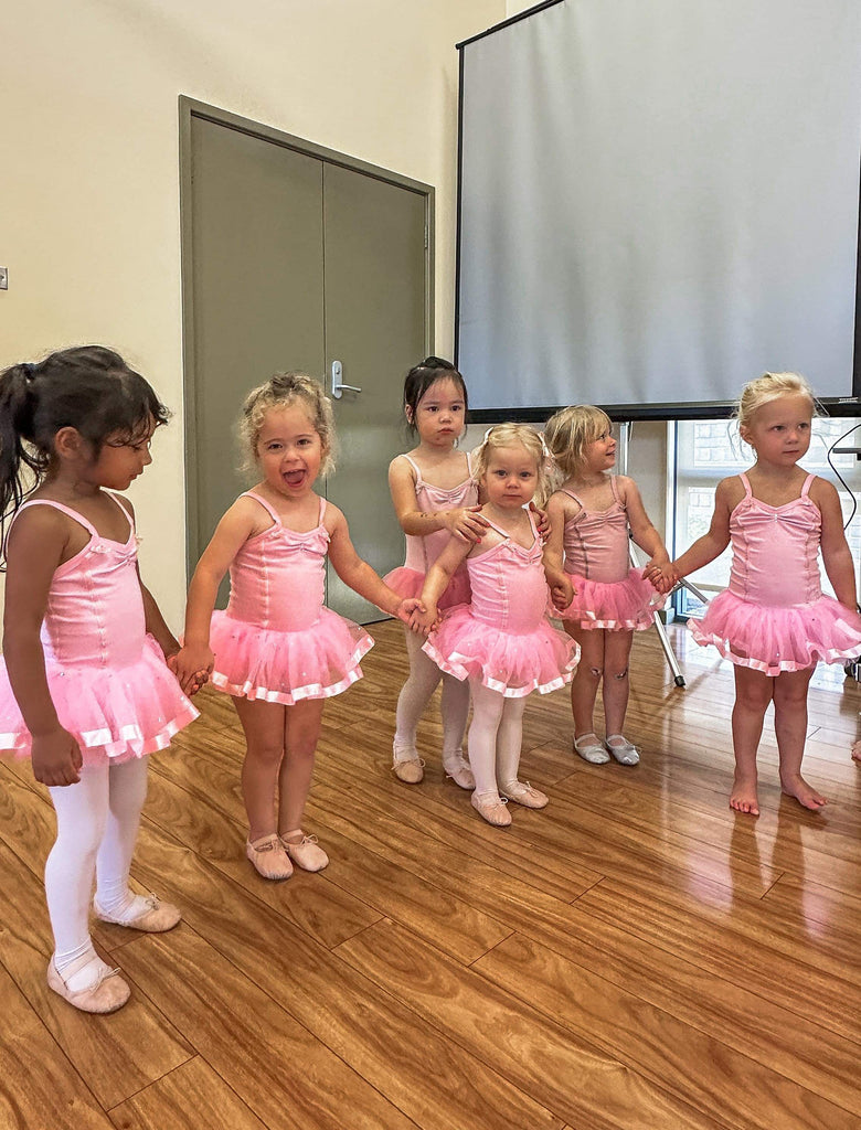 Ballerinas standing together holding hands in a ballet class for 3 year olds in Charlestown, Newcastle. 