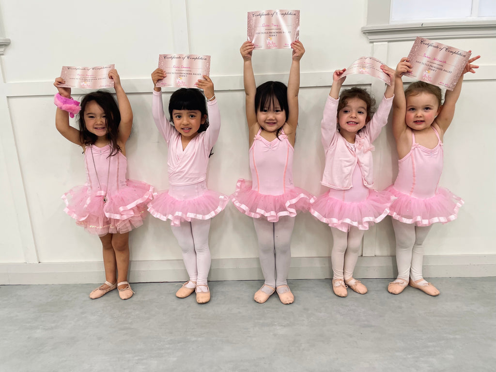 Five girls in a ballet class for 3 year olds in Brisbane holding certificates and smiling.
